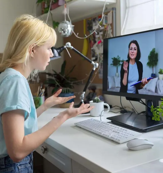 Woman having a virtual therapy session on a computer at home.