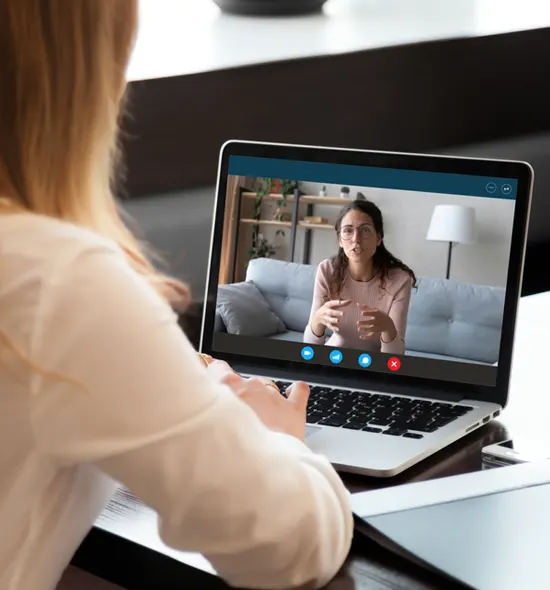 Woman in a video call on a laptop, discussing with a therapist.
